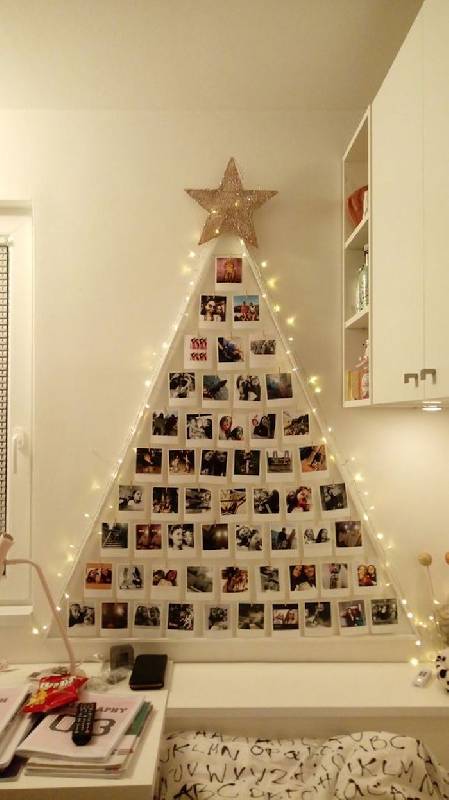 Un arbre de Noël au mur avec des photos 